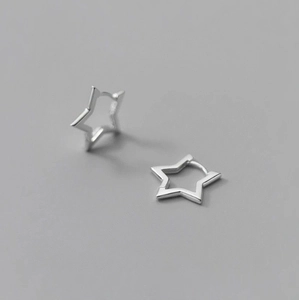 Boucles d'oreilles créoles étoiles argentées avec design évidé sur fond gris