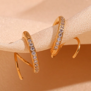 Détails macro de boucles d'oreilles spirales plaquées or 18K avec cristaux sertis CNC