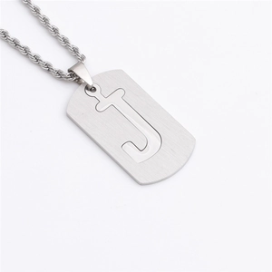 Détail d'un pendentif rectangulaire argenté avec lettre J ajourée et chaîne torsadée en acier