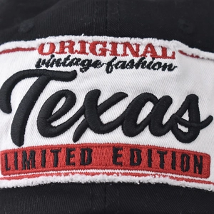 Close-up of high-quality Texas embroidery on a black washed cotton baseball cap