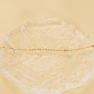 18k gold plated bracelet featuring sparkling cubic zirconia on a warm glass surface