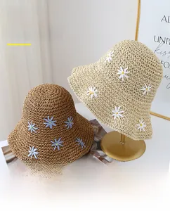Close-up of straw hats with UPF 50+ rating and delicate embroidered daisy flower patterns