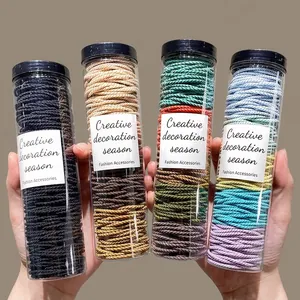 Set mit vier Farben hochelastischen Haargummis in einer klaren Aufbewahrungsflasche
