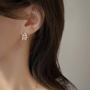Close-up of 925 sterling silver chain link earrings worn on a woman's earlobe