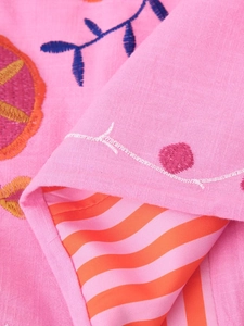 Detail of pink cotton-linen fabric featuring floral embroidery and striped lining