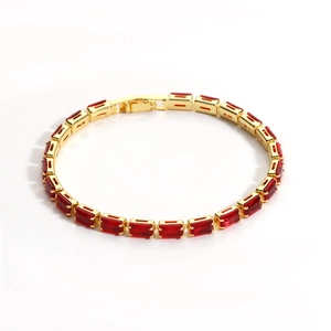 Detail of luxury single-row gold-plated tennis bracelet with red rectangular zircon stones