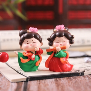 Close-up of traditional Chinese Tang Dynasty lady figurines playing flute on wooden desk