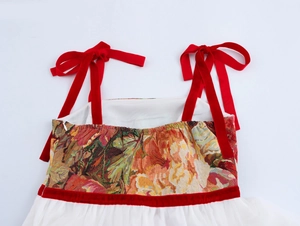 Dettaglio del corpetto jacquard vintage con fiocchi di velluto rosso e gonna a rete