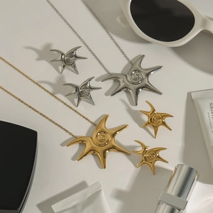 Polished starburst jewelry set with gold and silver necklaces and matching stud earrings