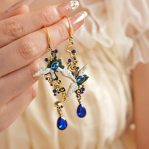 Detail of vintage enamel bird earrings with blue crystals and water drop pendants