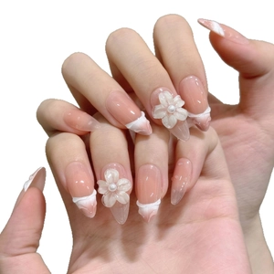 Faux ongles 3D faits main avec base rose nude, fleurs blanches et effet goutte d'eau