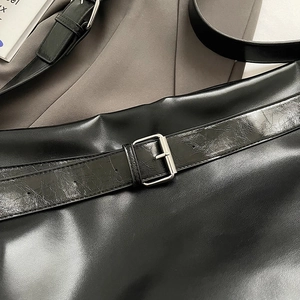 Gros plan du sac en cuir PU noir avec boucle argentée et détails plissés