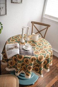 Detailed texture of thick jacquard tablecloth with sunflowers and beige tassels