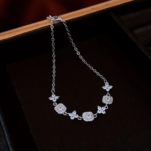 Detail of silver clover and square link bracelet with sparkling cubic zirconia stones