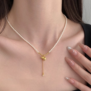 Elegant pearl necklace with golden gourd pendant and zircon tassel on model neck