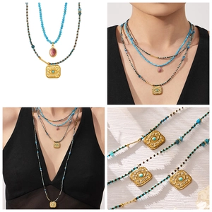 Detail view of bohemian turquoise beaded necklace with evil eye pendant and gold texture