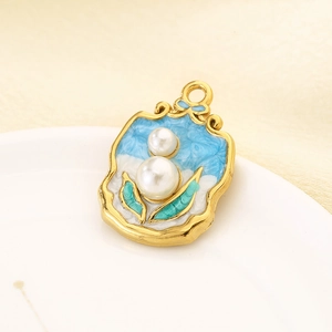 Détail macro d'un pendentif vintage en or 18K avec perle, fleur et émail bleu