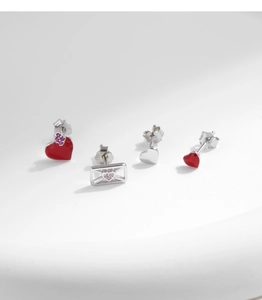 Detail of 925 sterling silver heart and envelope stud earrings set with zircon accents