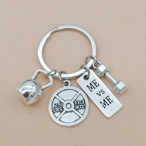 Detailed silver fitness keychain featuring kettlebell, dumbbell, and 25 LBS weight plate