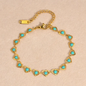 Macro detail of golden stainless steel heart bracelet with turquoise beads and clasp