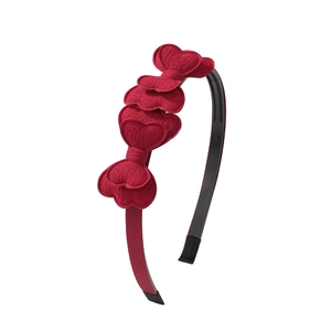 Close-up of a festive red headband with layered fabric hearts and ribbed texture