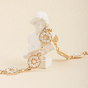Close-up of golden metal chain with round rhinestone links on a decorative statue