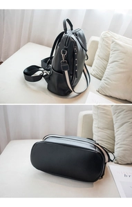 Detailed views of women's black leather backpack with striped straps and metal zippers