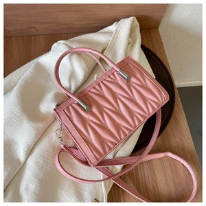 Detailed close-up of pink quilted leather texture with silver hardware on a luxury handbag