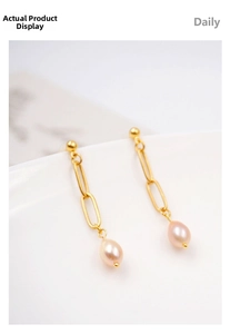 Macro shot of elegant gold chain earrings featuring lustrous drop-shaped rice pearls
