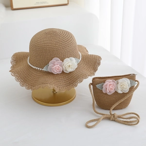 Detail of woven straw sun hat and matching bag set with elegant rose and pearl accents
