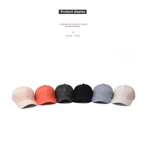 Row of baseball caps in pink, orange, grey, black, blue, and cream on white background