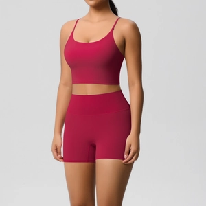Detail of high-waisted dark red yoga shorts and racerback sports bra with seamless texture