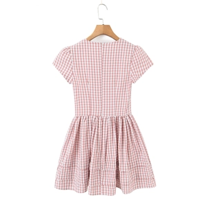 Détail de mini robe à carreaux rose et blanc avec manches bouffantes sur cintre