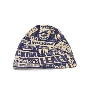 Knit slouchy beanie featuring a newspaper print design in cream and dark blue