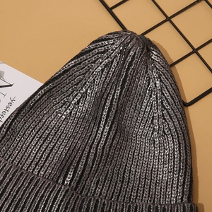 Detailed view of silver metallic knit beanie showing thick texture and sparkling finish