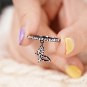 Macro shot of gun-black butterfly charm ring featuring sparkling zircon inlay detail