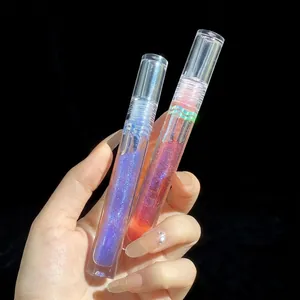 Macro shot of two high-shine glitter lip glosses in purple and coral on black background