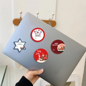 Christmas DIY stickers featuring Santa and Reindeer designs on a laptop surface
