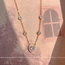 Detail of gold heart pendant with cubic zirconia and shimmering accents on dainty chain
