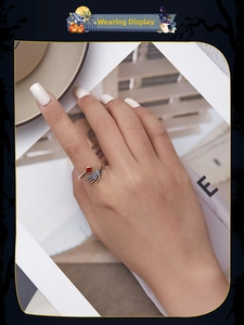 Gothic skull hand holding a red heart crystal ring on a model hand close-up