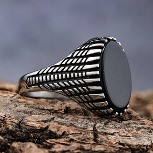 Vintage stainless steel ring for men featuring a black oval gemstone on wood base