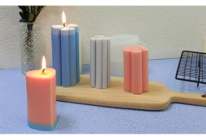 Vertical ripple heart pillar candles in pink blue and gray on a wooden tray