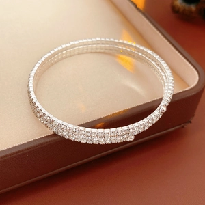 Close-up of triple-layered silver stretch bracelet with dense rhinestones on a leather box