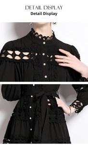 Detail view of lace texture, stand collar, and pearl buttons on a black dress
