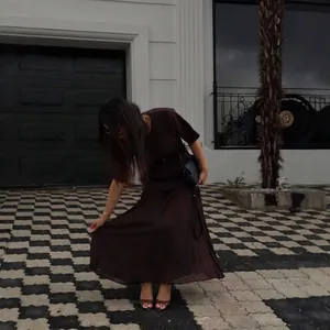 Brown short-sleeved pleated midi dress with chiffon hem in a minimalist outdoor street style