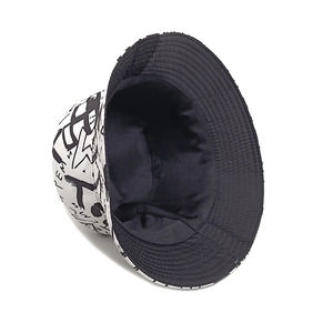 Detail of reversible bucket hat featuring black graffiti letters on white canvas fabric