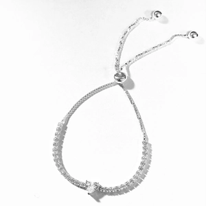 Detail of adjustable silver tennis bracelet featuring heart zircon and slider clasp