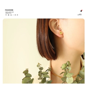 Close-up of gold screw-head stud earrings and matching chain necklace for a hip-hop look