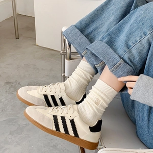 Baskets classiques en cuir noir et blanc avec semelle en gomme et chaussettes crème brodées