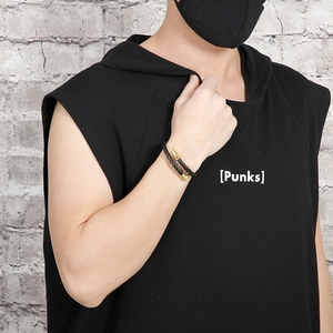 Close-up of black cable twisted bracelet with gold nail design on male model